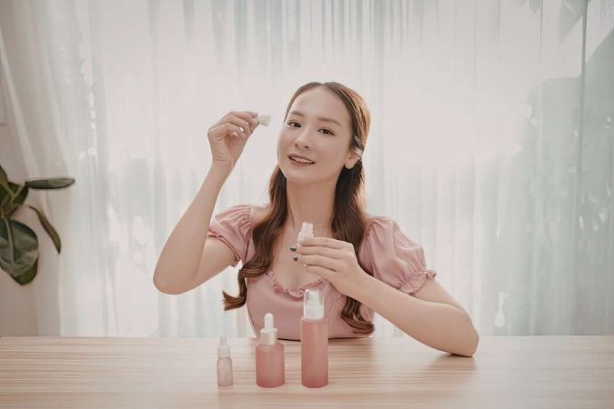 Femme appliquant un sérum dans une routine beauté minimaliste avec quelques produits essentiels