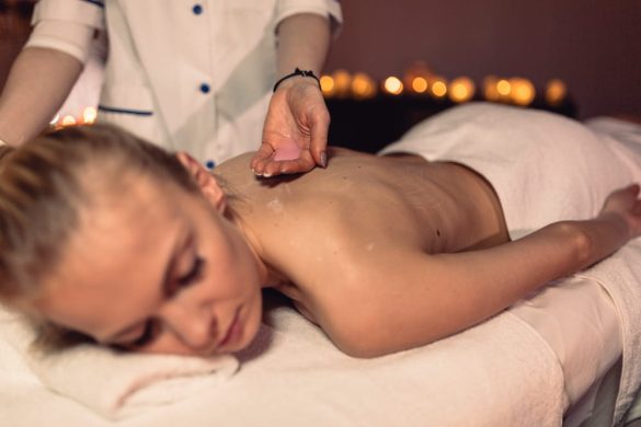 Une femme allongée sur une table de massage reçoit un soin du dos relaxant, idéale pour une idée de bon cadeau massage à Paris 17.