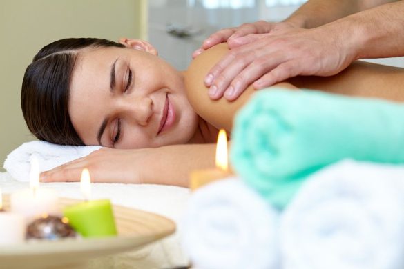 Une femme sereine recevant un massage du dos favorisant le massage et la libération des endorphines dans un cadre zen.